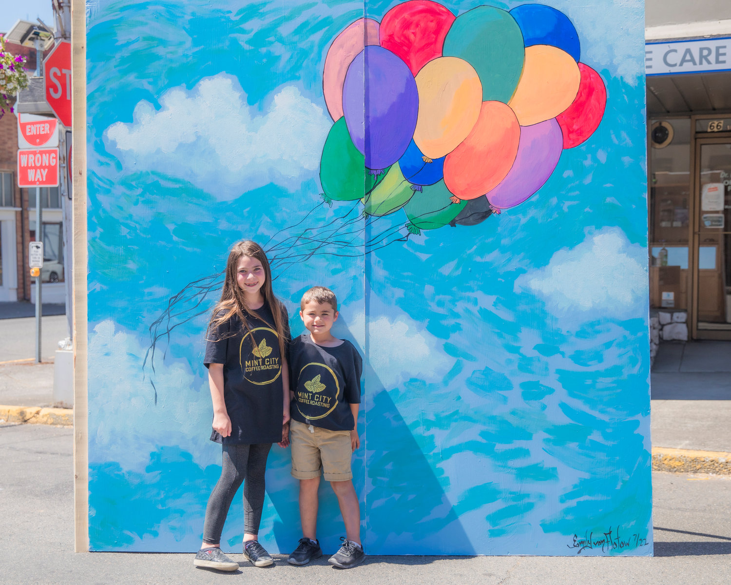 Kora, 10, and Landon Askin, 5, smile for a photo near artwork on display during Chehalis Fest Saturday afternoon.